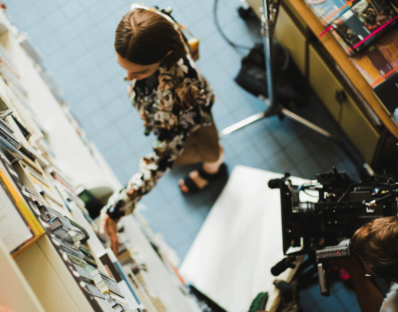 Cámara probando tipos de planos de una mujer tomando un libro de una estantería